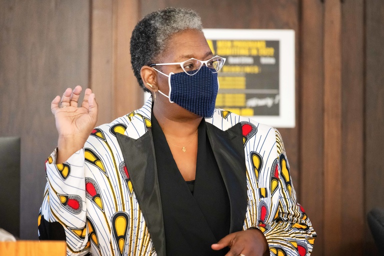 Professor Spears instructing class wearing a colorful print blazer and a face mask