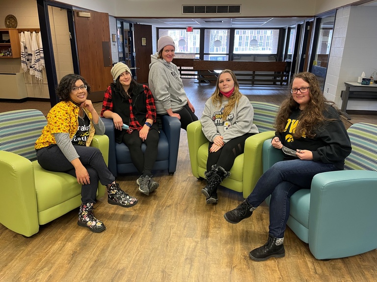 A group of five UI Social Work students, all women, posing in and around colorful chairs at Hillel House, Fall 2021