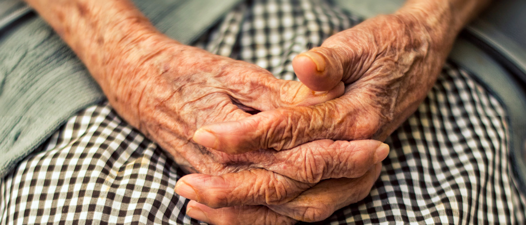 An elderly woman's hands resting in her lap.