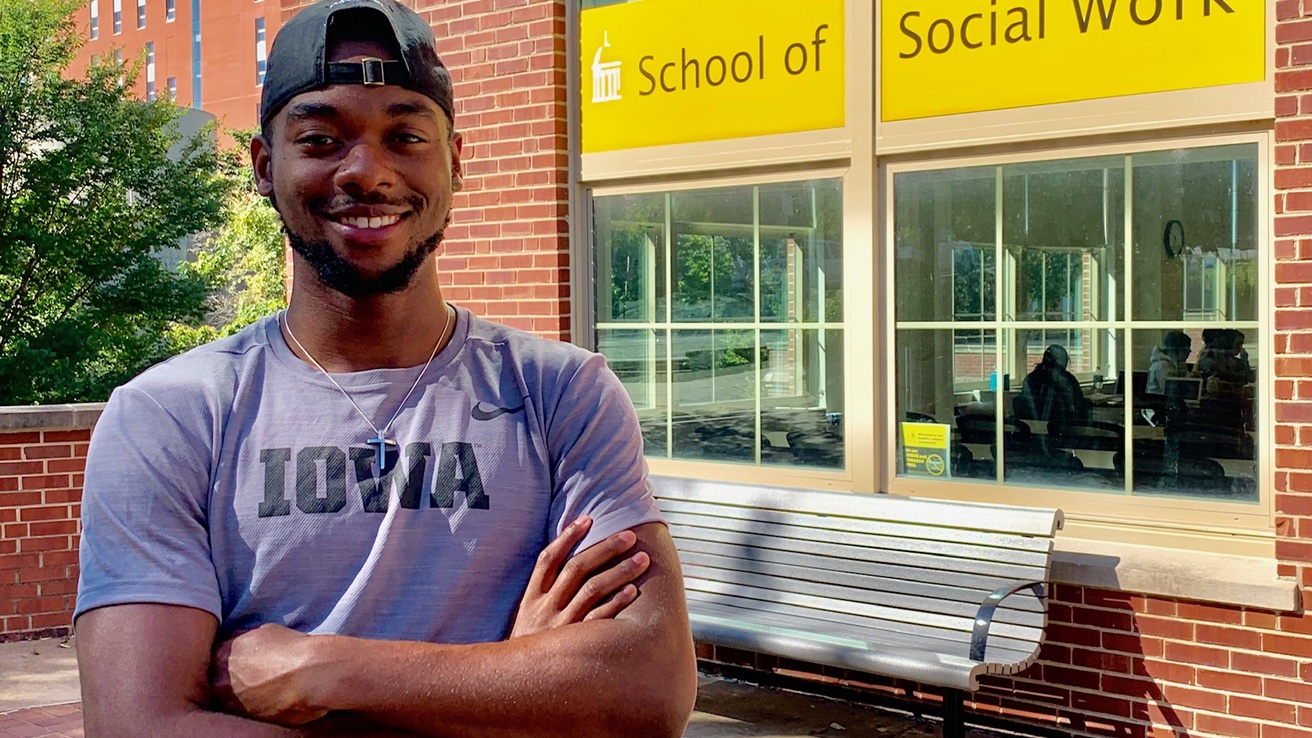 Antonio Woodard, standing with his arms crossed over a gray IOWA t-shirt in front of North Hall